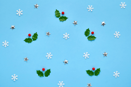 A xmas card. Christmas pattern of small white snowflakes and with figurines of shiny stars, Christmas berries on a blue background. Winter conceptの写真素材