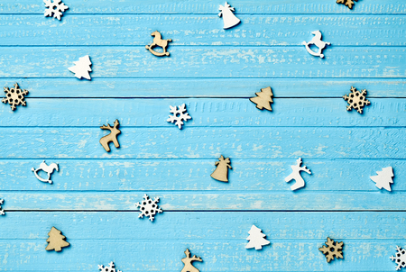 Holiday postcard. Christmas wooden decorations of fir, deer, snowflakes, horses on a background of blue vintage old wooden boardsの写真素材