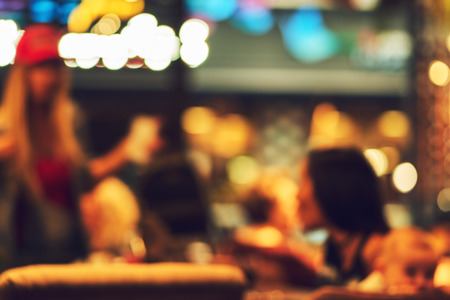 Blurred restaurant or cafe background. Tables and chairs in the lobby of the mall. Visitors to the restaurant for dinner. Beautiful bright interior. Blurred bokeh basic background for designの写真素材