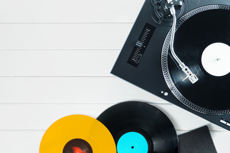 Festive postcard frame.Turntable vinyl record player on the background of their white wooden boards. Sound technology for DJ to mix & play music. Red, black, violet vinyl recordsの写真素材