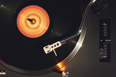 Turntable vinyl record player. Sound technology for DJ to mix & play music. Vintage vinyl record player on a background decorations for a party, bright disco lights. Needle on a vinyl recordの写真素材