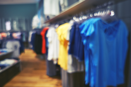 Blurred big sales on Black Friday. On sale at a clothing store in a modern shopping mall. Beautifully laid out things on hangers. Basic background for designの写真素材