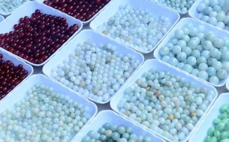 All kinds of jade beads are put in the dish の写真素材