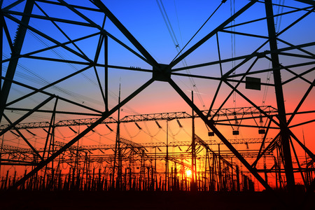 high voltage towers and power site under the setting sun
