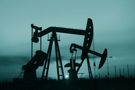 The setting sun is operation of the pumping unit in oil fieldの写真素材