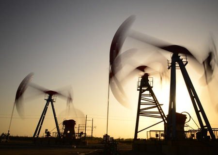 The setting sun is operation of the pumping unit in oil fieldの写真素材
