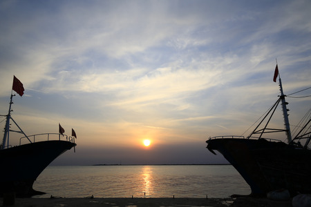 Fishing boats silhouetted against the setting sunのeditorial素材