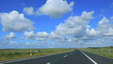 Beautiful highway, under the blue sky and white cloudsの写真素材