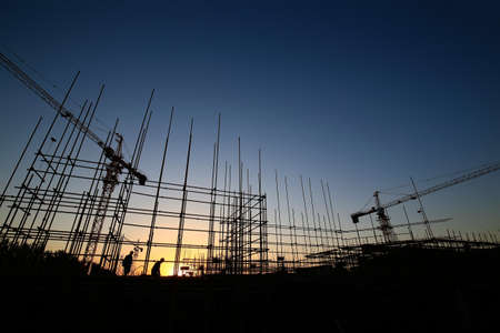 Cranes at work, silhouetted on construction sitesのeditorial素材