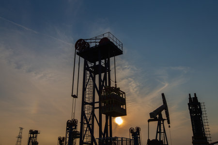 A silhouette of a pumping unit working in the eveningの写真素材