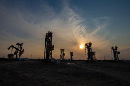 A silhouette of a pumping unit working in the eveningの写真素材