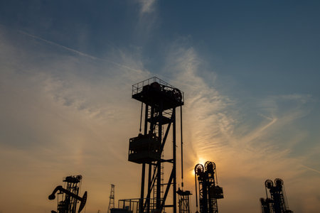 A silhouette of a pumping unit working in the eveningの写真素材