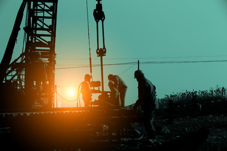 The oil workers at work during sunsetの写真素材