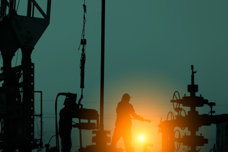 oil workers are working under sunsetの写真素材