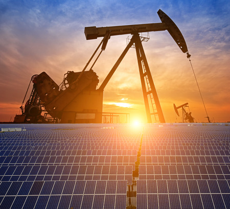 Oil pump with solar panels and the sunset
