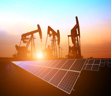 Clean power energy concept,Oil pump with solar panels and the sunset