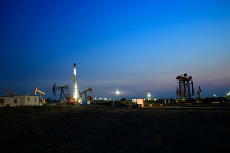 Oil drilling rig, Oil rig at the background of refinery by night. Oil and gas industry.の写真素材