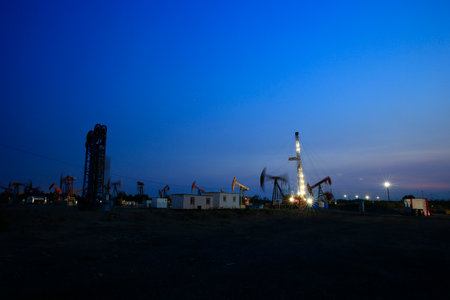 Oil drilling rig, Oil rig at the background of refinery by night. Oil and gas industry.の写真素材