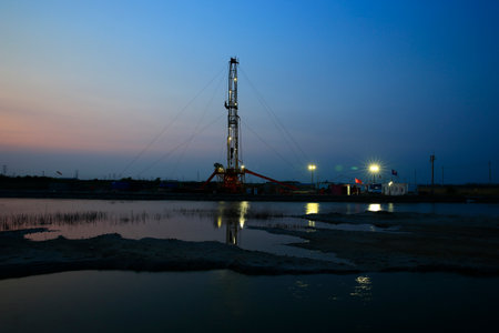 Oil drilling rig, Oil rig at the background of refinery by night. Oil and gas industry.の写真素材