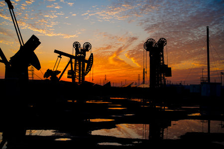The oil pump, industrial equipment. Oil field site, oil pumps are running, Extraction of oil.