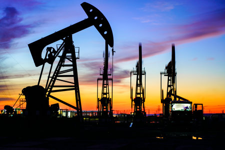 The oil pump, industrial equipment. Oil field site, oil pumps are running, Extraction of oil.