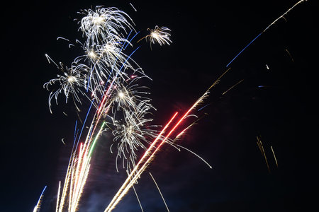 The dazzling fireworks bloomed in the dark night sky, with golden and white flower clusters falling...
