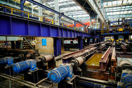 The core production area of hot rolling mill, blue drive motor array and rusty rolling roller table...
