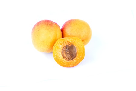 Three fresh sweet apricot fruit, whole and half, group of juicy ripe apricots closeup, isolated on...