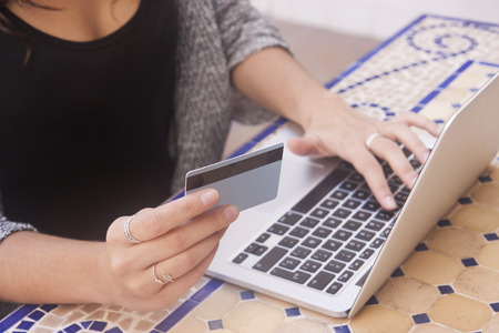 Close up of female hands making online payment.Woman sitting at the desk, shopping with laptop and...