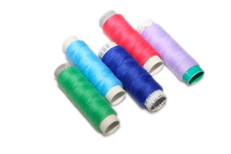 close up of color thread spool in white background