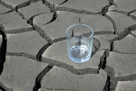 a transparent glass in the dry land, close-up, dry to the extreme, calling people to conserve water, protect the environment, Tangshan City, Hebei Province, China. の写真素材
