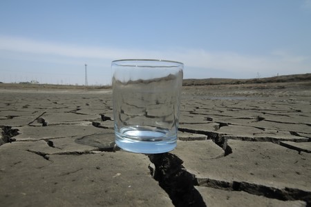 a transparent glass in the dry land, close-up, dry to the extreme, calling people to conserve water, protect the environment, Tangshan City, Hebei Province, China. の写真素材