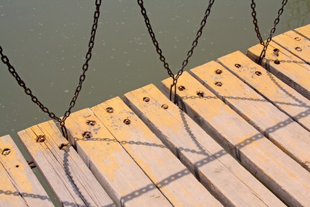 wood and iron chains of bridge in a park.の写真素材
