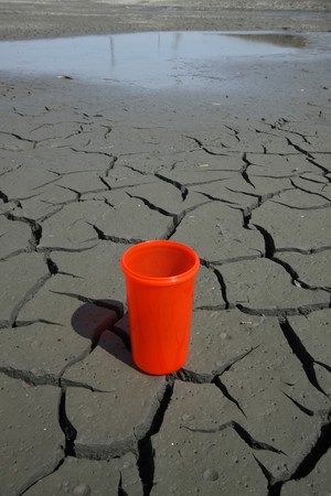close up of red plastic cups in the dry land, creative images, urged people to conserve water because the water crisis is worsening, it will affect all our lives. の写真素材
