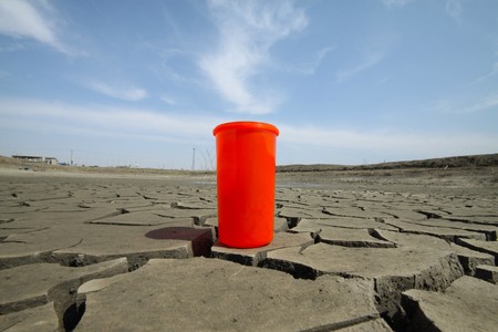 close up of red plastic cups in the dry land, creative images, urged people to conserve water because the water crisis is worsening, it will affect all our lives. の写真素材