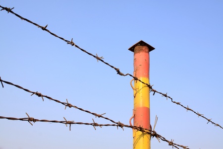 barbed wire fence under the blue sky 