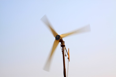 rotating wind turbine in blue skyの写真素材