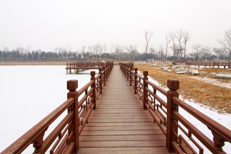 Chinese traditional style wooden bridge in a park の写真素材
