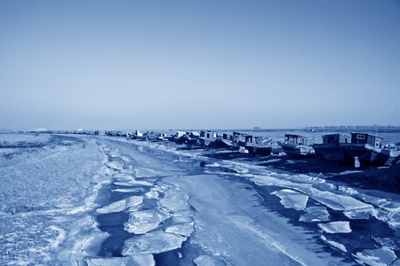 fishing boats berth by the river in winter, north chinaの写真素材