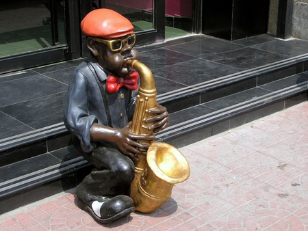 play an instrument of character sculpture in front of a restaurant door のeditorial素材