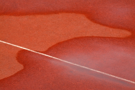 traces of water on red plastic runway in a sports groundの写真素材