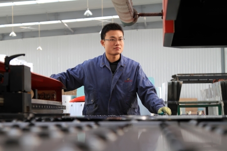 Luannan, November 24, 2012  A worker was operating CNC machine tools, in the DingRe Solar Energy Ltd, in November 24, 2012, Luannan County, china  The DingRe Solar Energy Ltd is the largest solar energy equipment manufacturers in Hebei province のeditorial素材