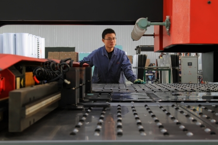Luannan, November 24, 2012  A worker was operating CNC machine tools, in the DingRe Solar Energy Ltd, in November 24, 2012, Luannan County, china  The DingRe Solar Energy Ltd is the largest solar energy equipment manufacturers in Hebei province のeditorial素材