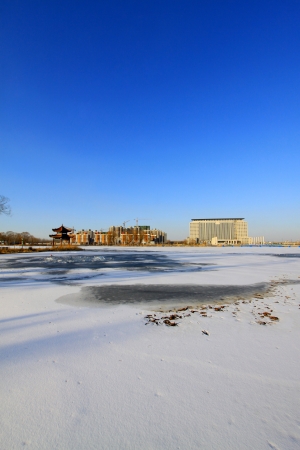 high rise buildings in the ice river edge in a park, North Chinaの写真素材