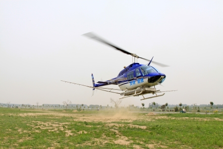 Luannan County - June 20: The helicopter is landing, prepares to refuel, then off again to spray...