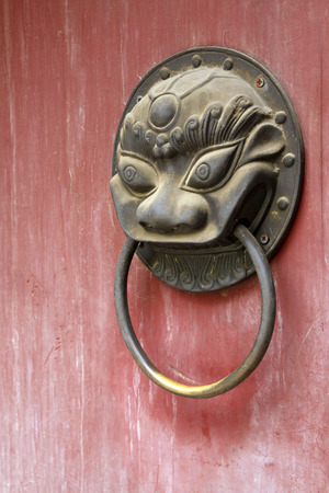closeup of pictures, metal beast head knocker on red door plank の写真素材
