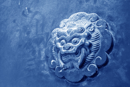 beast sculpture on red wooden door in a temple, closeup of photoの写真素材