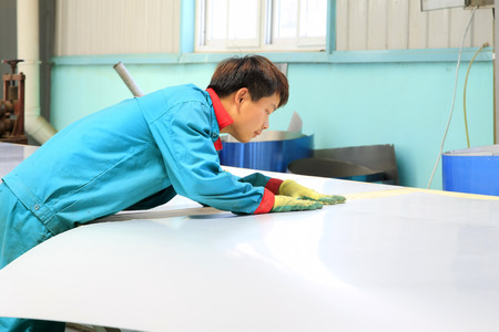 TANGSHAN CITY - MAY 29: Workers cutting stainless steel plate in a factory, on may 29, 2014, Tangshan city, Hebei Province, Chinaのeditorial素材