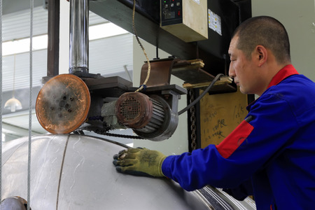 TANGSHAN CITY - MAY 29: Workers welding stainless steel shell in a production workshop, on may 29, 2014, Tangshan city, Hebei Province, Chinaのeditorial素材