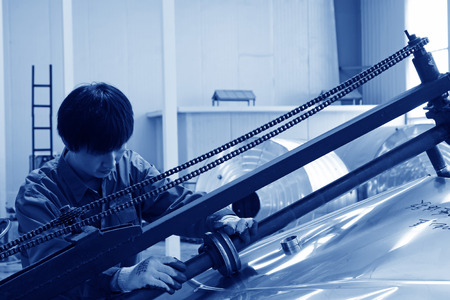 TANGSHAN CITY - MAY 29: Workers pressed stainless steel parts in a production workshop, on may 29,...